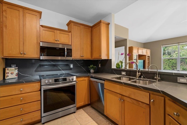 237 Kuli Puu St, Kihei, HI 96753 - kitchen featuring appliances with stainless steel finishes, a sink, brown cabinetry, tasteful backsplash, and dark countertops