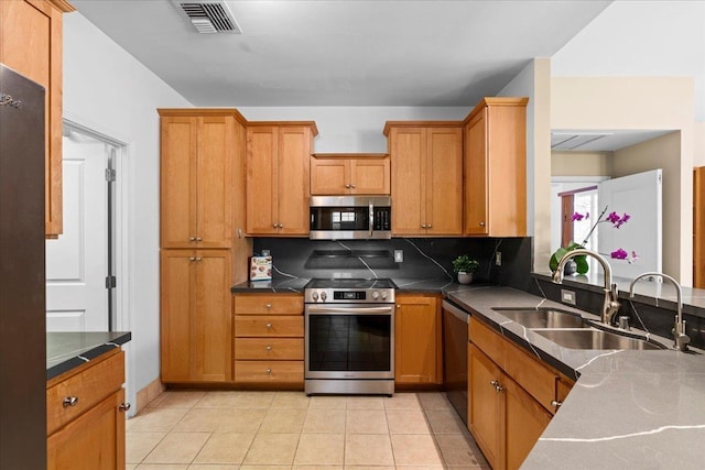 237 Kuli Puu St, Kihei, HI 96753 - kitchen featuring stainless steel appliances, a sink, decorative backsplash, brown cabinetry, and light tile patterned floors