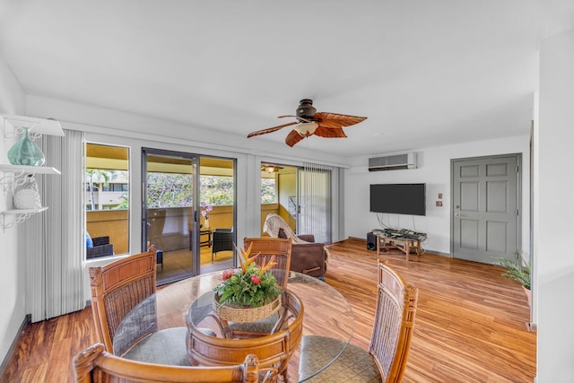 dining area featuring an AC wall unit, a ceiling fan, french doors, and wood finished floors