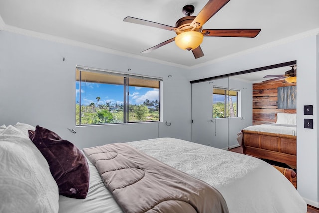 bedroom featuring a ceiling fan, ornamental molding, wood finished floors, and a closet