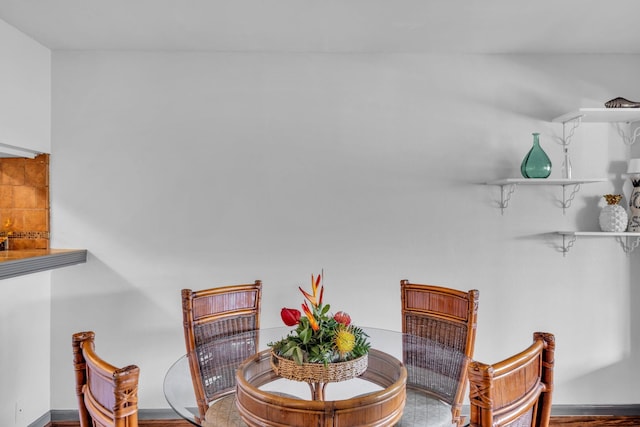 dining area featuring baseboards and wood finished floors