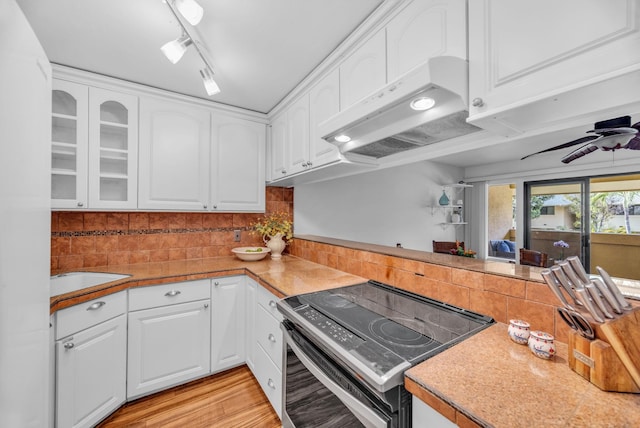kitchen featuring under cabinet range hood, stainless steel electric range, and white cabinetry
