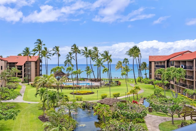 view of property's community with a water view and a yard