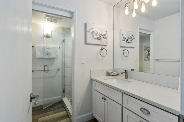 bathroom featuring a shower with door, hardwood / wood-style flooring, toilet, and vanity