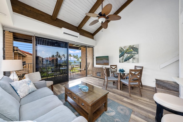 living room featuring a wall mounted AC, hardwood / wood-style floors, beamed ceiling, and ceiling fan