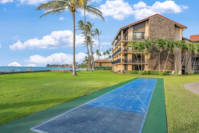 view of home's community with a water view and a yard