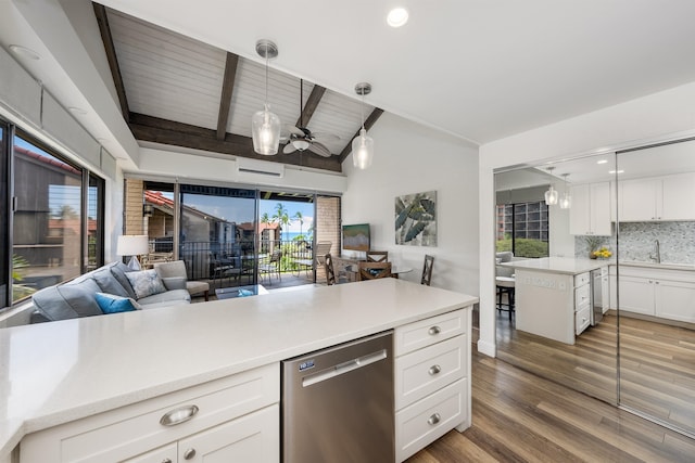 kitchen with tasteful backsplash, dishwasher, vaulted ceiling with beams, hanging light fixtures, and hardwood / wood-style flooring