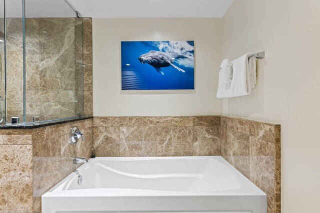 bathroom featuring shower with separate bathtub