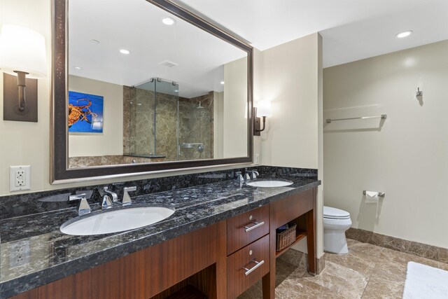 bathroom featuring vanity, toilet, a shower with shower door, and tile patterned floors