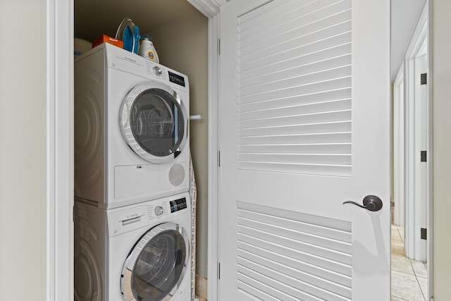 washroom featuring light tile patterned floors, laundry area, and stacked washer / drying machine