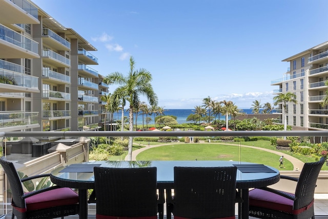 view of patio featuring a balcony, a water view, and outdoor dining area