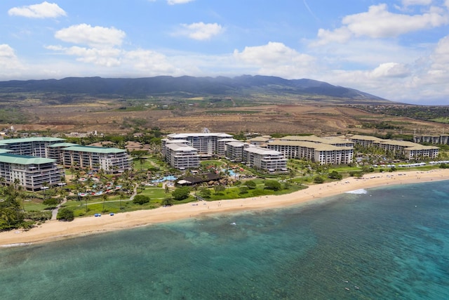 bird's eye view featuring a view of the beach, a water and mountain view, and a view of city