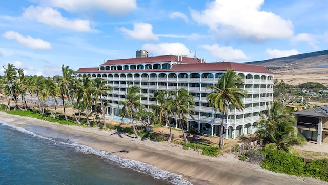 view of building exterior featuring a water view and a view of the beach