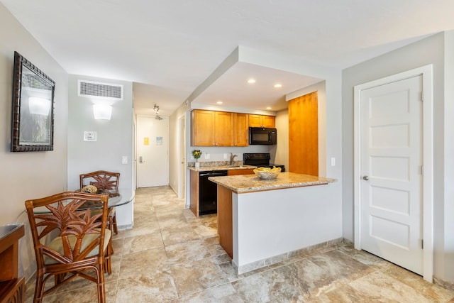 kitchen with black appliances, light stone counters, kitchen peninsula, and sink