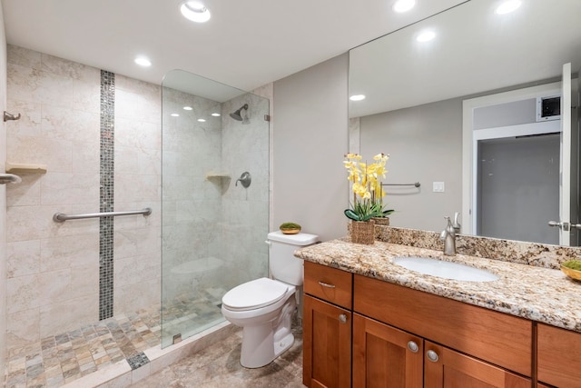 bathroom featuring vanity, toilet, and tiled shower