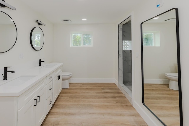 bathroom featuring double sink vanity, hardwood / wood-style flooring, and toilet