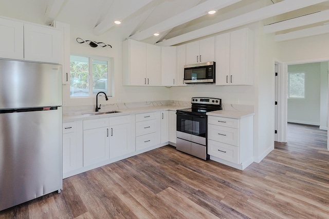 kitchen with dark hardwood / wood-style flooring, stainless steel appliances, and white cabinets