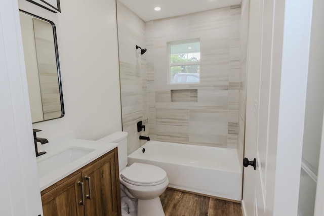 full bathroom featuring tiled shower / bath, toilet, vanity, and hardwood / wood-style floors