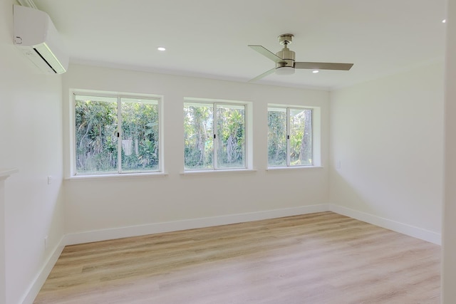 empty room featuring ceiling fan, light hardwood / wood-style floors, and an AC wall unit