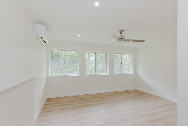 unfurnished room with light hardwood / wood-style flooring, ceiling fan, and a wall unit AC