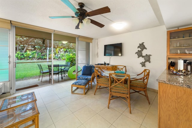 tiled dining area featuring ceiling fan and a textured ceiling