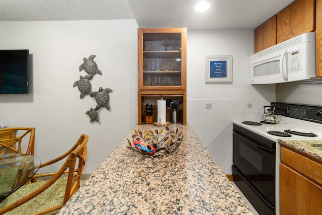 kitchen with light stone counters and white appliances