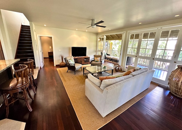 living room featuring ceiling fan and dark wood-type flooring