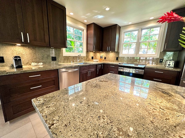 kitchen with light stone counters, tasteful backsplash, electric range, and stainless steel dishwasher