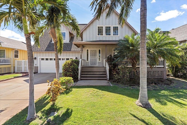 view of front of home with a front lawn, covered porch, and a garage