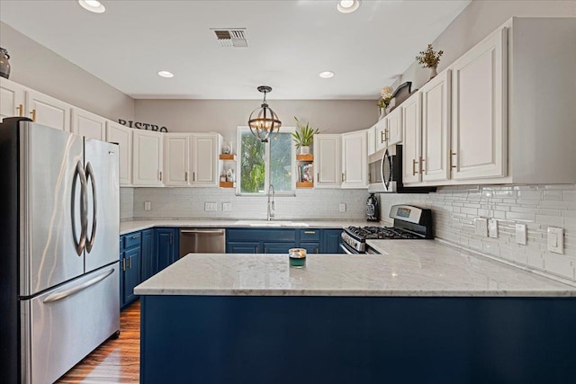 kitchen with white cabinetry, hanging light fixtures, stainless steel appliances, blue cabinets, and hardwood / wood-style flooring