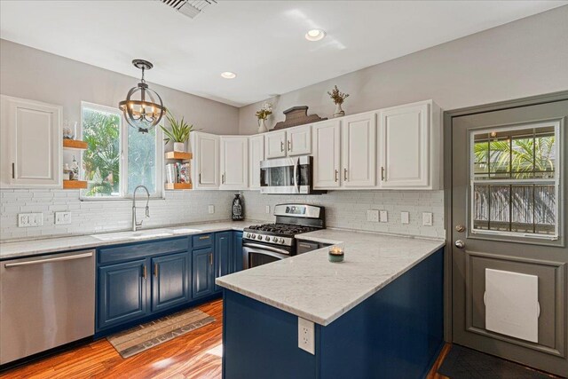 kitchen with white cabinets, stainless steel appliances, a healthy amount of sunlight, and sink