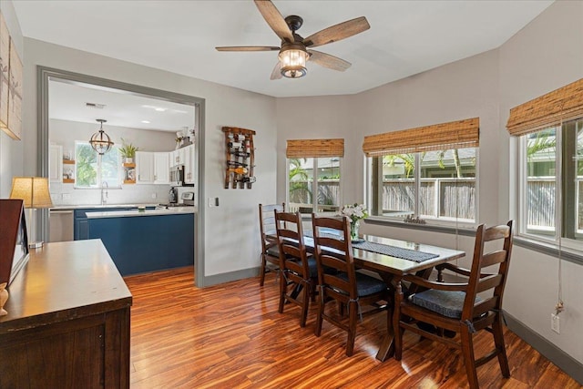 dining area with wood-type flooring, ceiling fan, and a healthy amount of sunlight