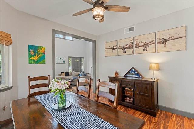 dining space with ceiling fan, plenty of natural light, and dark wood-type flooring