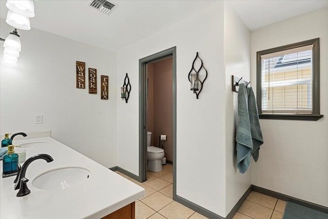 bathroom featuring tile patterned flooring, vanity, and toilet