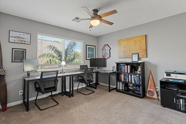 carpeted home office featuring ceiling fan