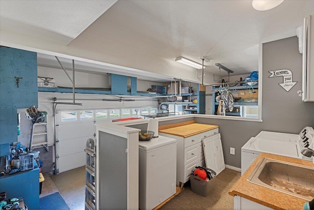 washroom with a textured ceiling, independent washer and dryer, and sink