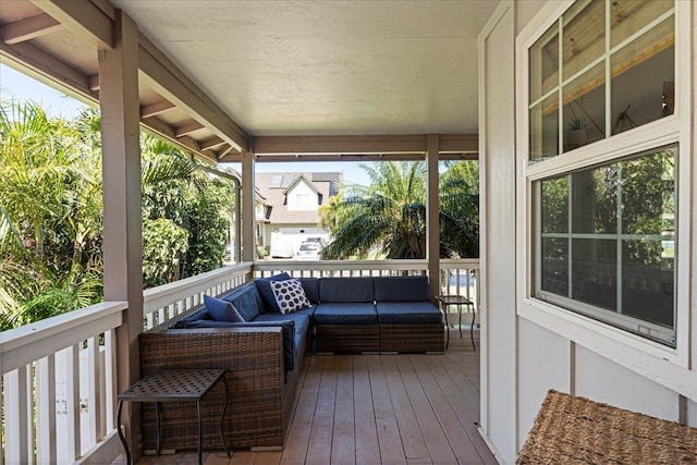 wooden terrace with an outdoor living space