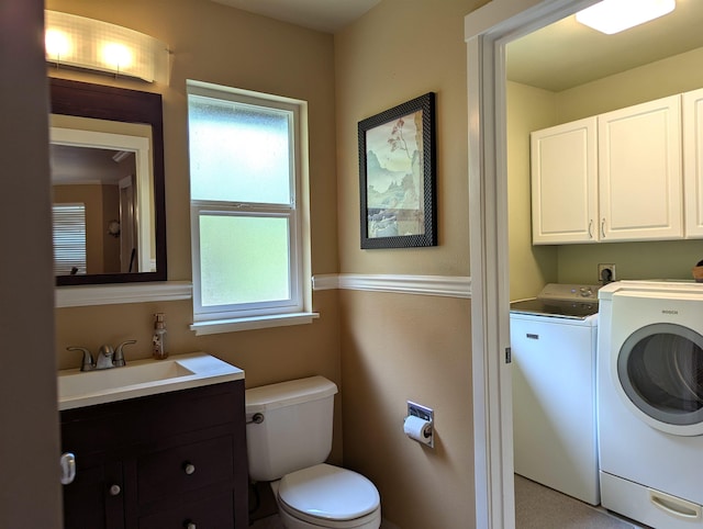 bathroom with vanity, toilet, and washer and dryer