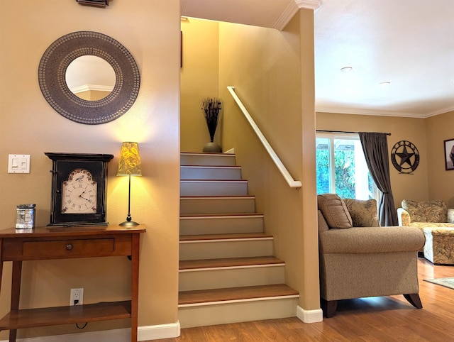 stairs with hardwood / wood-style flooring and ornamental molding