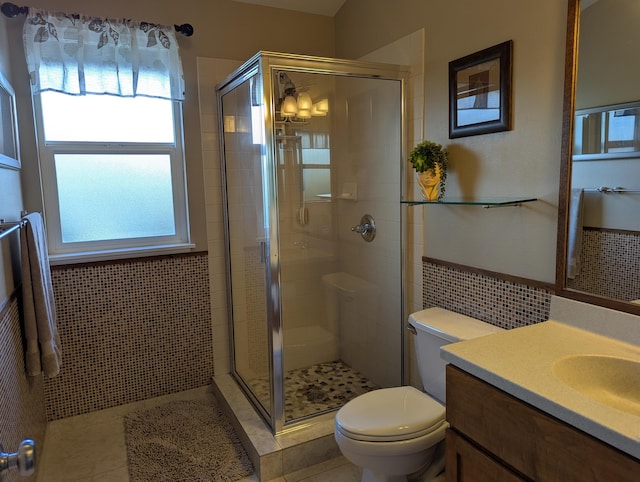 bathroom featuring tile walls, tile patterned flooring, vanity, toilet, and a shower with door