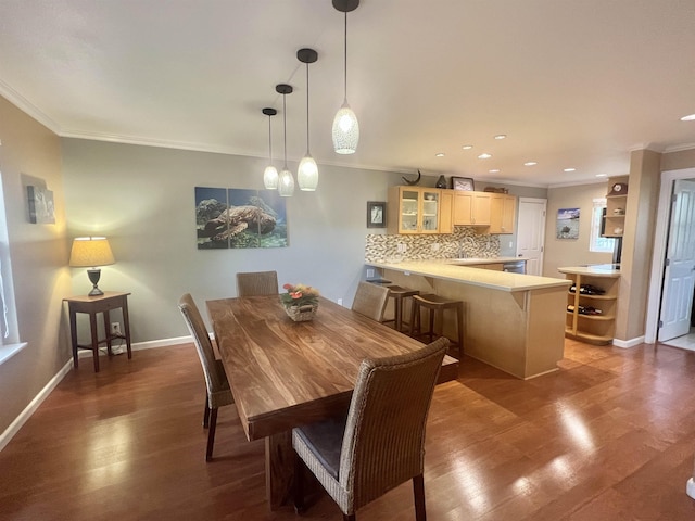 dining space with ornamental molding and dark hardwood / wood-style flooring