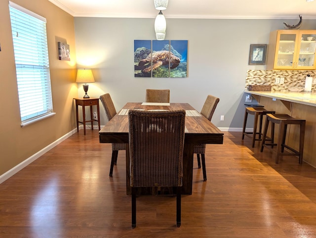 dining space featuring crown molding and dark hardwood / wood-style floors