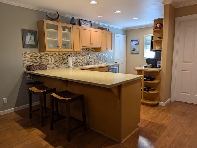 kitchen with sink, hardwood / wood-style floors, a kitchen breakfast bar, and kitchen peninsula