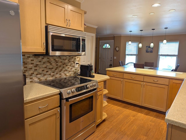 kitchen with pendant lighting, ornamental molding, light brown cabinets, and appliances with stainless steel finishes