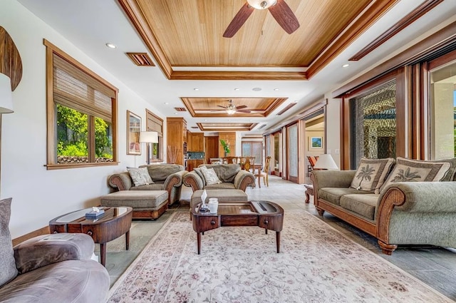 living room featuring ceiling fan, a raised ceiling, ornamental molding, and tile patterned floors