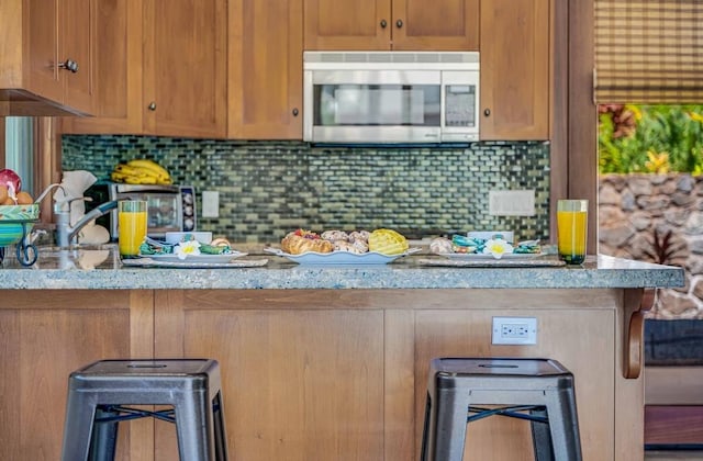 kitchen with decorative backsplash and light stone countertops