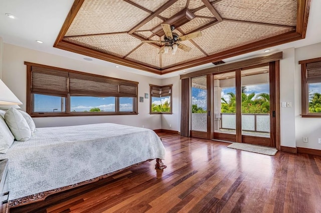 bedroom featuring access to exterior, dark hardwood / wood-style flooring, coffered ceiling, a tray ceiling, and ceiling fan