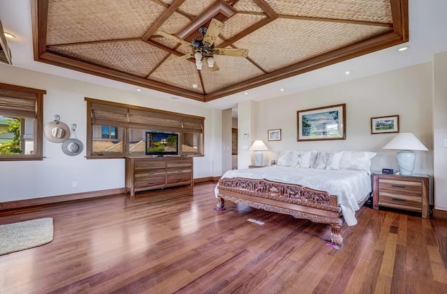 bedroom featuring ceiling fan, a tray ceiling, and hardwood / wood-style floors