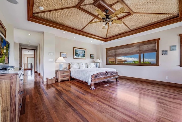 bedroom with ceiling fan, a raised ceiling, dark hardwood / wood-style floors, and coffered ceiling