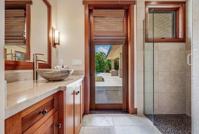 bathroom with tile patterned floors, walk in shower, and vanity